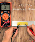 Digital multimeter measuring current with probes on circuit board covered with Kapton tape, showcasing its insulation properties.