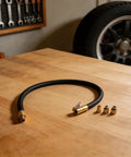Universal 60CM Tire Inflator Hose With Quick Connect Valve Adapter For Cars Trucks And SUVs Featuring Rock Solid Reinforced Rubber Rated Up To 300 PSI Max Pressure For No Fuss Inflation At Home Or Shop And Save Time Driving Today, black hose on bench