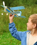 Child holding a model airplane outside
