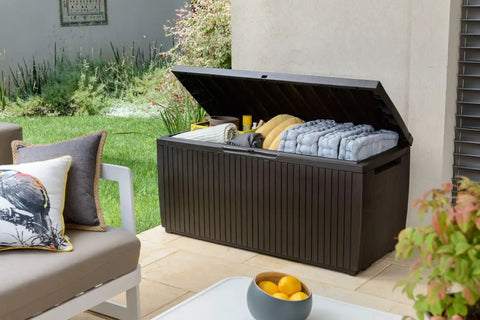Springwood 80 Gallon Resin Outdoor Storage Box for Patio Cushions, Pool Toys, Garden Tools with open lid, showing storage with natural surroundings