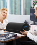 Two people in an office smiling with Under Desk Foot Rest For Office And Home, Ergonomic Foot Stool With Washable Cover in front of them.