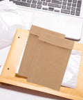Kraft Paper Envelopes With Honeycomb Padding And Double Layer Design on a desk with a laptop, 50 Pack visible