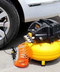 Pancake Portable Electric Oil Free Air Compressor With Two Couplers, 6 Gallon Tank, 135 PSI beside car tire in garage