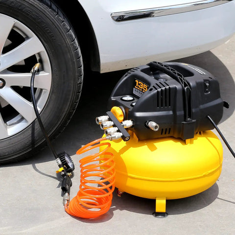 Pancake Portable Electric Oil Free Air Compressor With Two Couplers, 6 Gallon Tank, 135 PSI beside car tire in garage