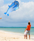 Person flying Large Dolphin Blue Kite Frameless Soft Parafoil Giant 3D Kite For Beach And Outdoor Fun Times on beach.
