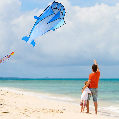 Person flying Large Dolphin Blue Kite Frameless Soft Parafoil Giant 3D Kite For Beach And Outdoor Fun Times on beach.