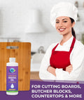 Food Grade Mineral Oil For Cutting Boards And Wood Surfaces Restore And Protect Cutting Boards Butcher Blocks Countertops And Steel Surfaces With Non GMO Vegan Gluten Free USP Approved Low Viscosity For Maximum Wood Absorption bottle next to a wood cutting board with a smiling chef in the background.
