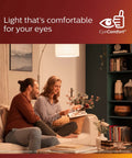 Couple reading under warm glow of Vintage G25 Amber Edison Filament LED Bulbs in cozy living room setting, EyeComfort design
