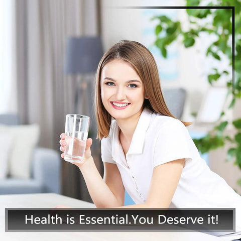 Woman smiling and holding a glass of water indoors