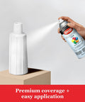 Person applying Legit Heavy Duty Acrylic Clear Spray Paint For Indoor Outdoor Projects on a white vase, 12 oz aerosol can in use.