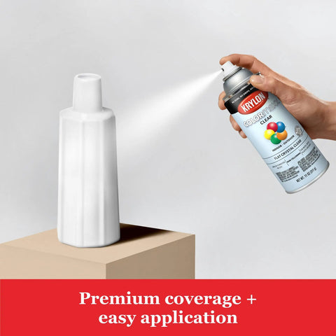 Person applying Legit Heavy Duty Acrylic Clear Spray Paint For Indoor Outdoor Projects on a white vase, 12 oz aerosol can in use.