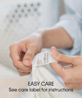 Person holding care label of Duck Solid Box Cushion Sofa Slipcover One Piece With Elastic Seat Seam Relaxed Fit No Fuss 100 Percent Cotton Duck Canvas.