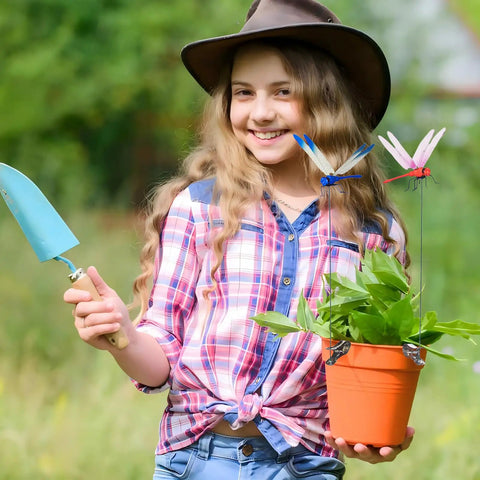 Young girl with hat holding potted plant with Dope Dragonfly Clip 12 Pack For Garden Decor And Outdoor Stakes DIY Fake Dragonfly Clips