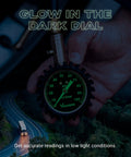 Front view close-up of a 2-inch Vondior tire pressure gauge with a glow-in-the-dark green dial held in hand.