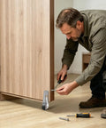 Man installing Heavy Duty Vertical Track Roller Wheels And Bottom Support Casters For Sliding Gates 2 Piece Kit on a wooden door.