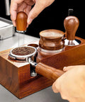 Kickass Espresso Organizer And Height Adjustable Tamping Station For 51mm 54mm And 58mm Portafilters Solid Wood Coffee Counter with tamper preparing ground coffee.