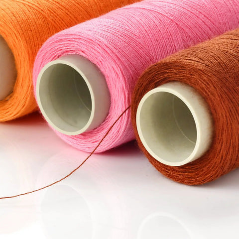 Close-up of 12 Color Sewing Thread Kit With Needle Threader For Hand And Machine, DIY Home Sewing Set showing pink, brown, orange spools.