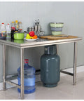 Heavy Duty 304 Stainless Steel Work Table With Adjustable Height And Slick Removable Top Rock Solid Commercial Prep Bench Built To Last For Warehouse Packing Or Shop Use with kitchen items and a water dispenser.
