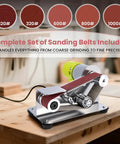 Pro Mini Belt Sander And 15 Degree Belt Grinder With Seven Speeds, showcasing a complete set of sanding belts on a wooden table.