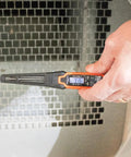 Hand using digital pocket thermometer from HVAC Tool Kit With 3 In 1 Pocket Screwdriver 8 In 1 Screwdriver And Nut Driver And Digital Pocket Thermometer Compact Pocket Friendly 3 Piece Set For Quick HVAC Repairs And Everyday Jobsite Fixes on reflective surface, close-up view.
