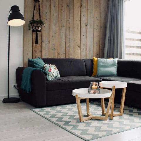 Modern living room with black sofa, wooden accent wall, and floor lamp providing bright light. A19 LED Light Bulb 100W Equivalent Daylight Dimmable 15W Energy Saving Bulb With 10,000 Hour Lifespan 16 Pack White Bright Light For Home And Office Spaces illuminating room.