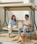 Two people sitting on Three Seat Outdoor Patio Swing With Adjustable Canopy And Backrest Convertible Glider Bed On Stand