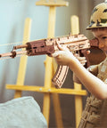 Child playing with Wooden 3D AK47 Puzzle Model With Rubber Band Shooter Detachable Magazine And Two Fire Modes Cool DIY Wood Craft Kit For Adults