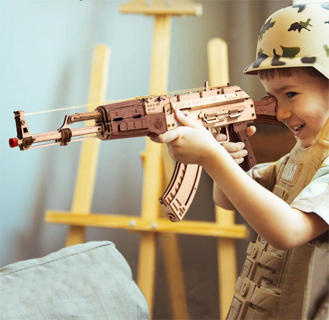 Child playing with Wooden 3D AK47 Puzzle Model With Rubber Band Shooter Detachable Magazine And Two Fire Modes Cool DIY Wood Craft Kit For Adults