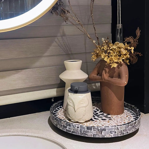12 Inch Wooden Lazy Susan With Mother Of Pearl Inlay Smooth Spinning Turntable Serving Tray holding vases and dried flowers on a counter.