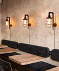 Industrial Plug In Wall Light E26 Base Edison Wire Retro Style Vintage Wall Lights Cage Rustic Sconce in a cafe setting