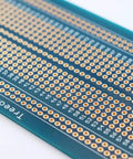 Close-up of Universal Solderable Breadboard PCB Prototype Shield Double Sided Board With Tinned Gold Plated Holes for prototyping
