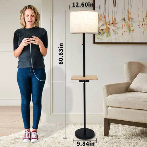 Woman using Dope Modern Floor Lamp With Dual USB Ports And Rectangle Tray Table, 60 Inches Tall, Linen Shade, shown next to sofa.
