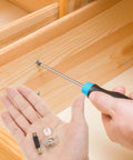 Person assembling furniture with screwdriver, showing Cam Lock Fastener Kit For Cabinets And Wardrobes 24 Sets With 35mm Plastic Rods.