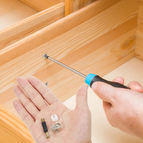 Person assembling furniture with screwdriver, showing Cam Lock Fastener Kit For Cabinets And Wardrobes 24 Sets With 35mm Plastic Rods.