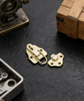 Six Piece Golden Metal Hasp Latches With Strong Locking Toggle For Toolboxes Trunks Cabinets And Chests To Secure Your Gear on black surface.