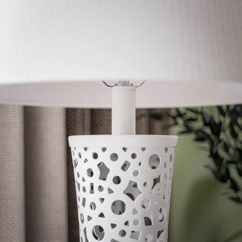 Close-up of bright white ceramic table lamp with bubble pattern, showing shade and base detail, modern living room light.