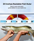 Sidomma 24-inch reelable fish ruler with blue sections; measuring a bass, lifebuoy visible in background.