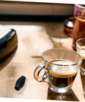 Heat Insulation Pad Rubber Sleeve For Espresso Steam Wand Burn Protection next to coffee cup on wooden table