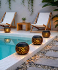 Outdoor Solar Lanterns Waterproof For Porch Garden Patio Vintage Leaf Pattern Metal Lanterns With Warm Flame Light next to pool