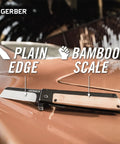 Quadrant Clip Folding Knife With Bamboo Handle, 2.7 Inch Stainless Plain Edge Blade on a car hood