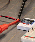 Two Pack Multimeter Test Lead Set With Wire Piercing Probes And Insulated Back Probes For Diagnostic Electrical Testing, Pro Grade 4mm Banana Plug Leads For Automotive Use, Heat And Cold Resistant, Non Slip Grip connected to a circuit board.
