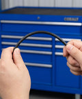 Hands holding a flexible black PP plastic welding rod for car bumper repair from the 100 Pc set.
