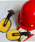 Job Site Tough Safety Hard Hat Ear Muffs With Integrated Noise Blocking Cups For Industrial Hearing Protection And Heavy Duty Construction Environments next to a red hard hat.