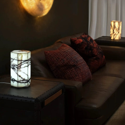 Lit Real Marble Hexagon Table Lamp With Tri Color Dimmable LED on a bedside table in a dimly lit living room