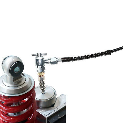 Front view of 5-piece nitrogen needle valve kit for shocks with Schrader valve and metal fittings on a red coil-spring suspension