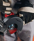 Professional Grade 1300W 230V Angle Grinder Featuring 125MM Disc Size for cutting metal on a workshop table.
