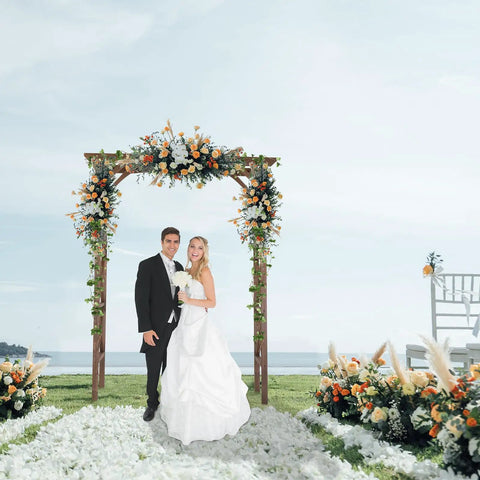 Sturdy 6.6Ft Wooden Garden Arbor Wedding Arch Backdrop Stand for Ceremony with couple under floral decorations by the sea
