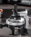 Heavy Hitter Rotary Espresso Puck Distributor Tool Featuring Adjustable Height And 12 Precision Points To Crush Clumps Level Coffee Grounds Evenly Compact Barista Accessory For Home Daily Driver Setup close-up on a sleek silver and black design with rotary handle.