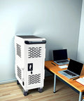 Top Tier Mobile Charging Station Holding Sixteen Devices Features Hella Sturdy Steel Body Secure Lock System And Built In Power Strips Fits Fourteen Inch Tablets Smooth Ride Casters Best For Classrooms Or Clinics White in corner with laptops.