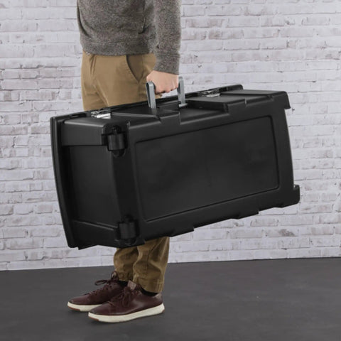 Person carrying the Flex Your Storage Game With Heavy Duty Plastic Footlocker Rolling Bin With Wheels And Handle, Stackable Tote Featuring Secure Latching Lid For Basements Dorms And Shared Spaces, Smooth Operator Hauler Chest In Black.